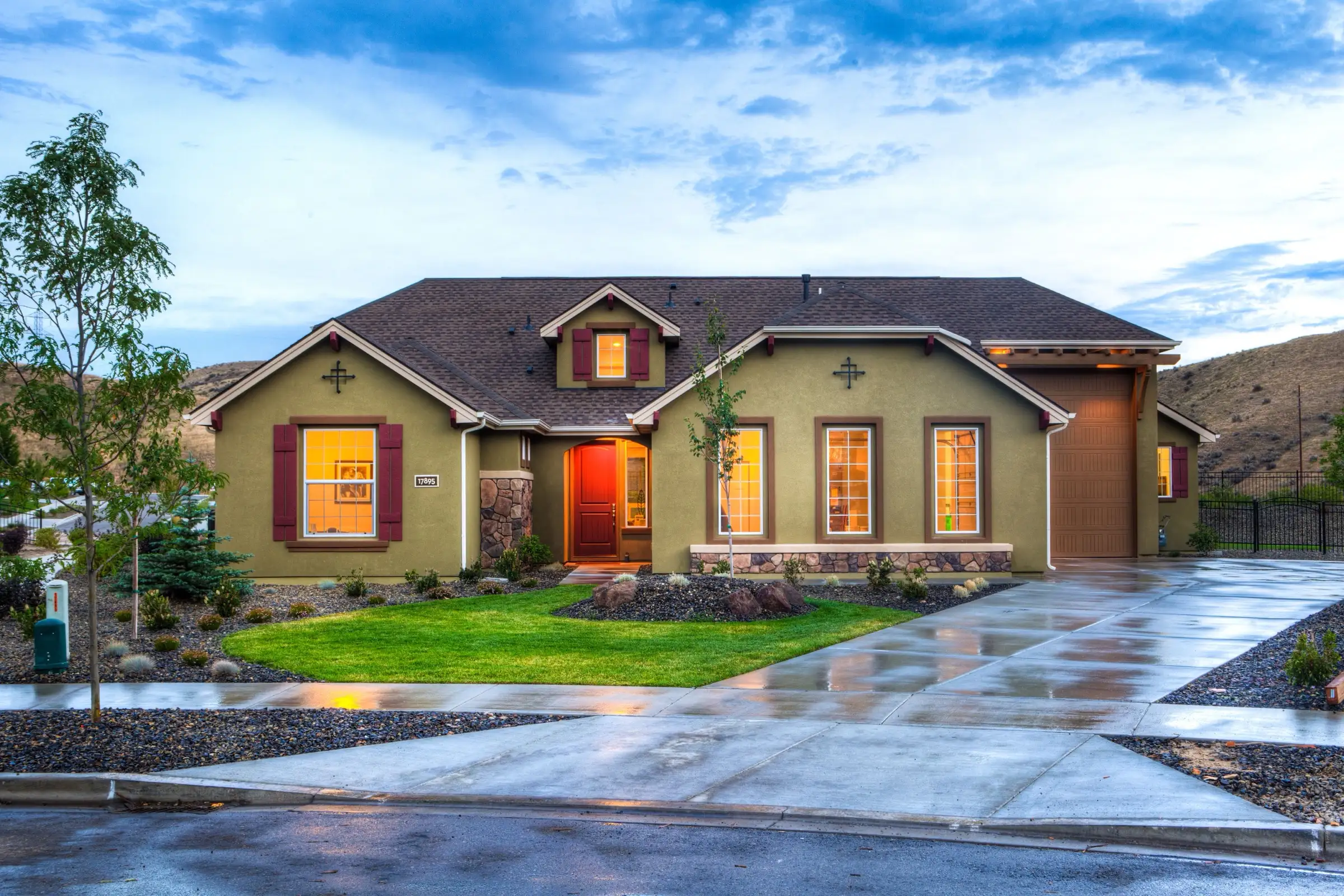 Single family home at dusk with exterior lighting on